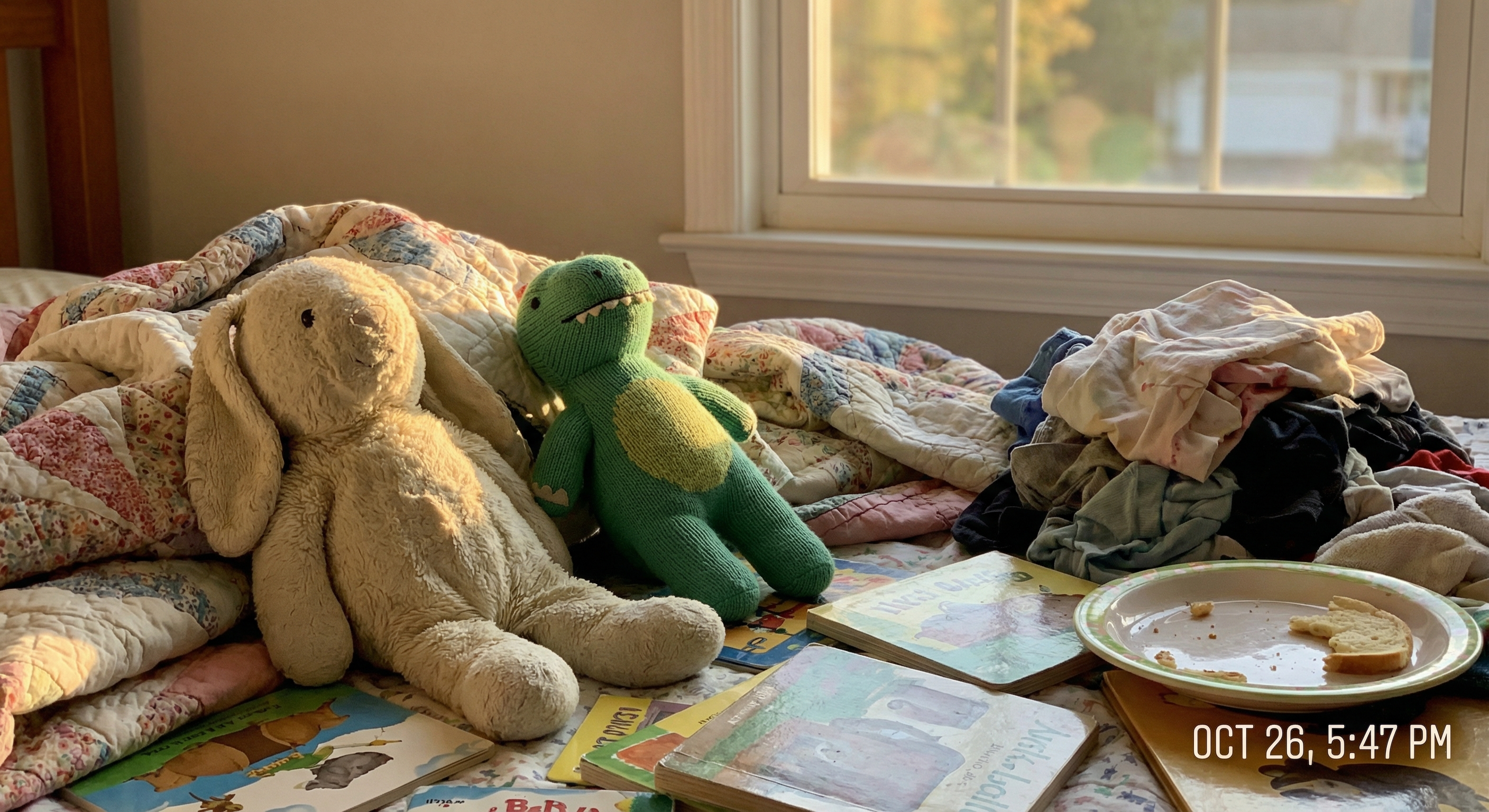 Kuschelhase und Stoff-Dinosaurier auf einem Bett im warmen Abendlicht